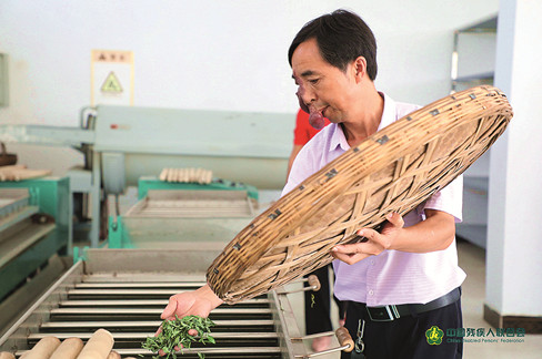 徐从德在茶厂里对刚杀青的茶叶进行再加工。_副本.jpg