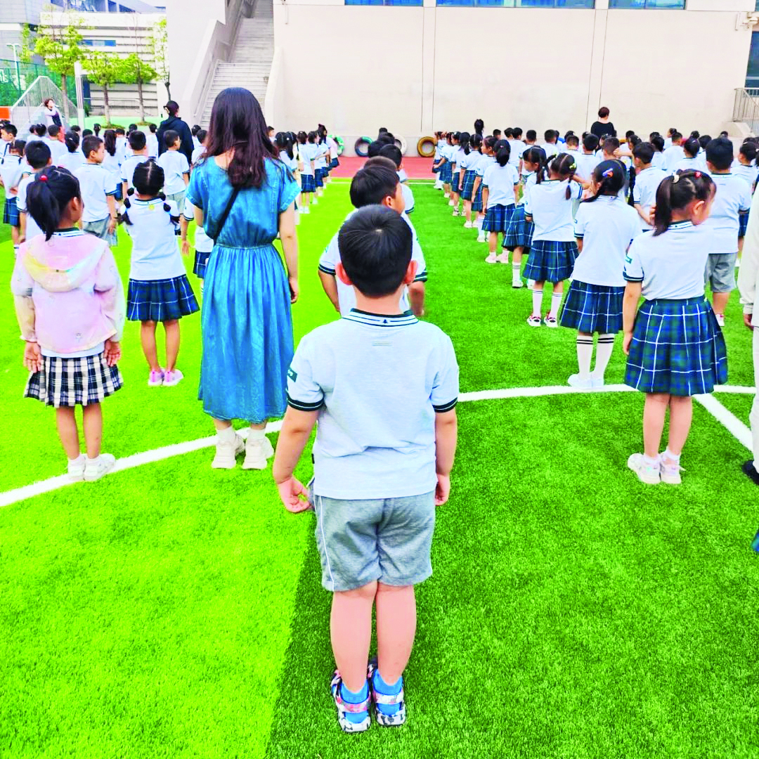 江苏省南京市尝试“半日制”融合教育方式，由机构派出的影子老师进行随班伴读，助力其融入普幼生活。图为孤独症孩子在影子老师的陪伴下，在普校参加校园活动。（图片由南京明心儿童益智教育培训中心提供）.jpg